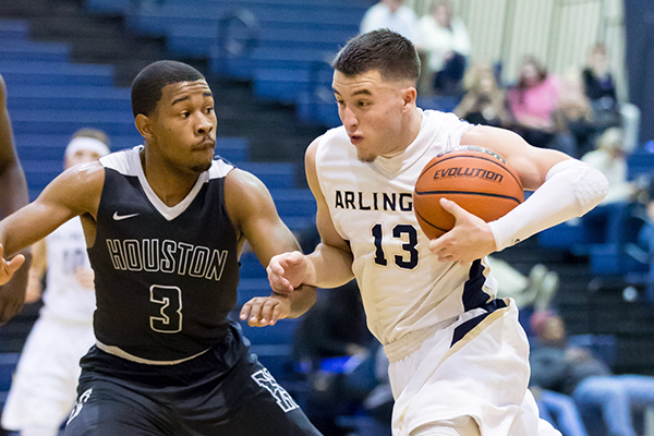 AHS Senior, Sam Wiseman, dodging Houston High School player during basketball game.