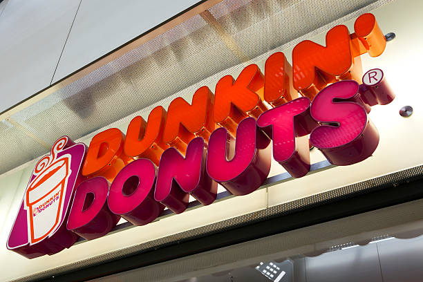 Getty Images. Essen, Germany - September 1, 2011: Dunkin Donuts sign at shop entrance. Dunkin Donuts is an international doughnut and coffee retailer founded in 1950, headquartered in Canton, Massachusetts.
