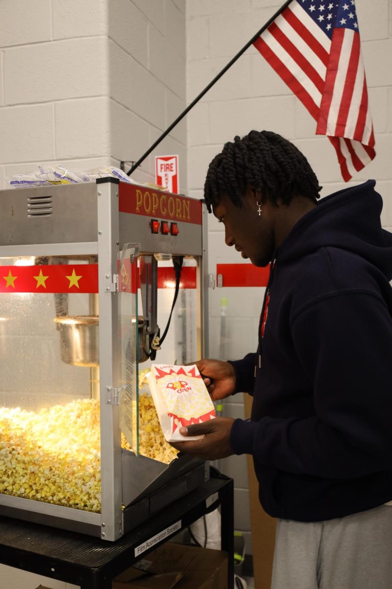 Jhabari Ellis fills his popcorn bag during the first Media Arts meeting of the year.