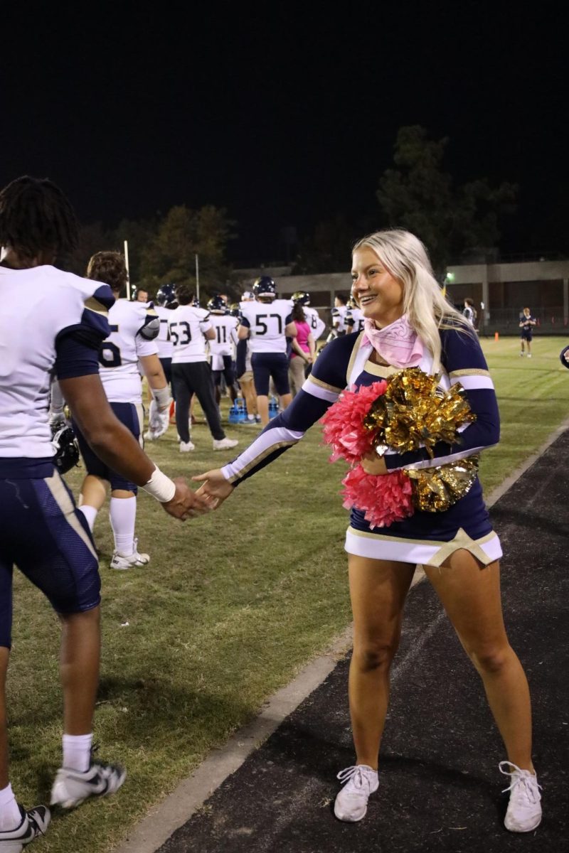 Cheerleader, Braylin Ramage, supports and Arlington football player.